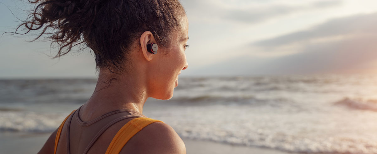 nők igazi vezeték nélküli fejhallgatót használnak a tengerparton