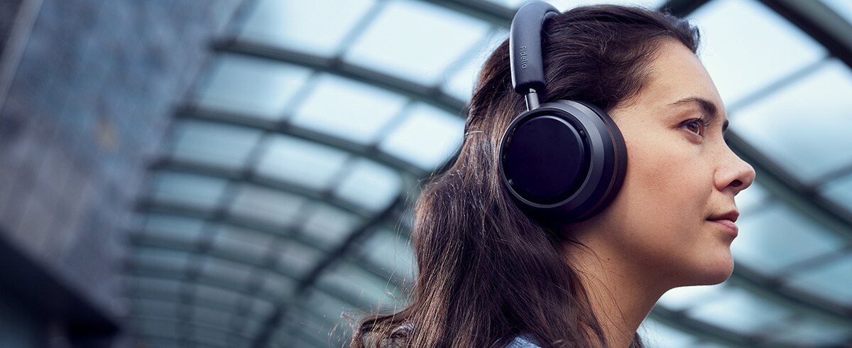 Nő élvezi a zenét utazás közben Philips L4 fejhallgatóval