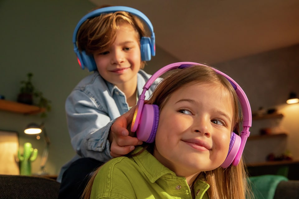 Két testvér játszik a fülhallgató gyerek fejhallgató használata közben