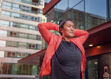Nő, aki Philips A5508 vezeték nélküli fejhallgatót használ a szabadban