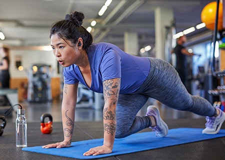 Woman actively exercising while using Philips A5508 true wireless headphones