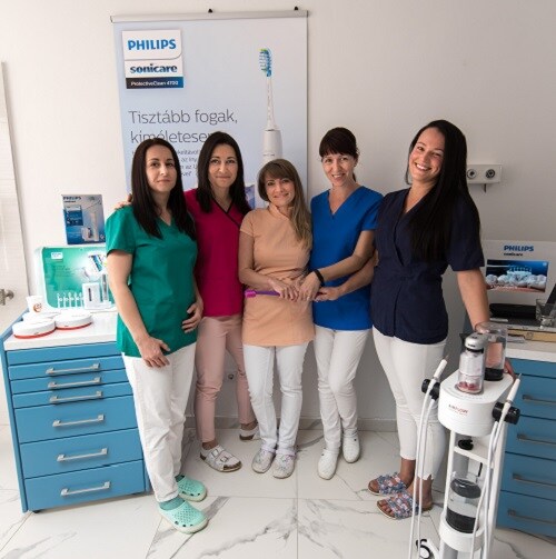 Five dentist smiling to camera at their workplace